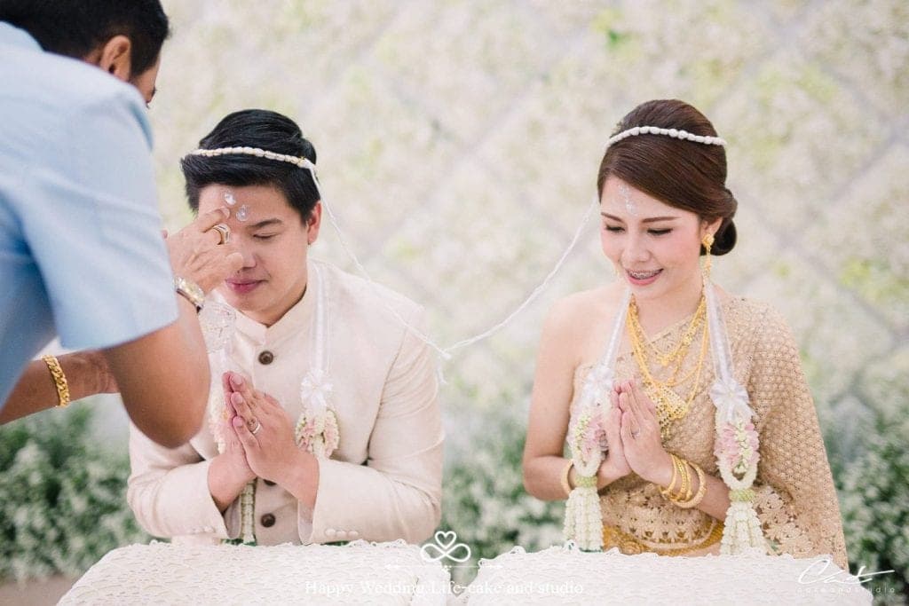 Pasangan pengantin Siam dalam upacara pemberkatan dan renjis air mawar.