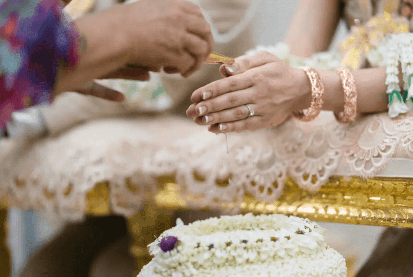 Air disiram pada tangan pengantin sebagai sebahagian daripada upacara pemberkatan Siam.